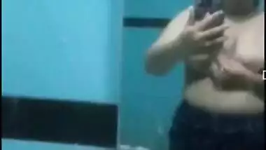 Desi sweet thing touches soft natural breasts in front of a mirror